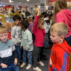Fru Feldmann guider børn gennem biblioteket