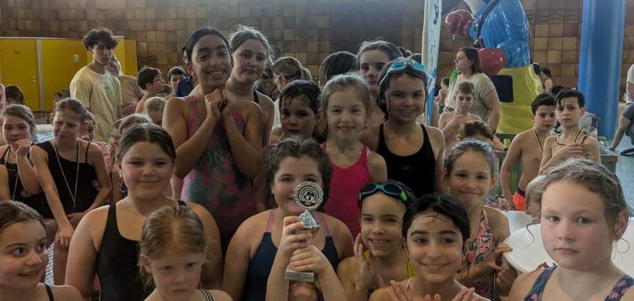 Niños de la escuela Viktoria en la competición de natación por relevos 2025 en la piscina cubierta de Gronau.