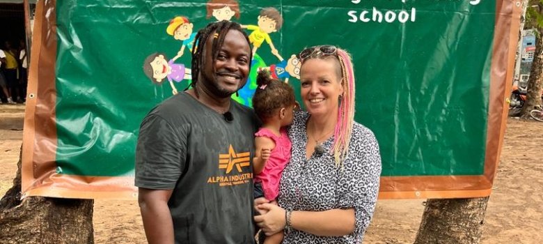 Janine Hundt avec son mari et sa fille devant la bannière de l'école