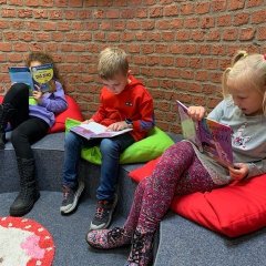Tre bambini leggono nell'angolo della lettura