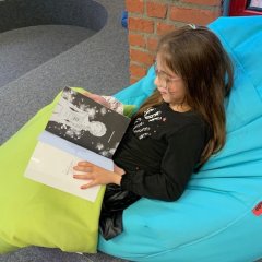 Una ragazza legge nell'angolo lettura