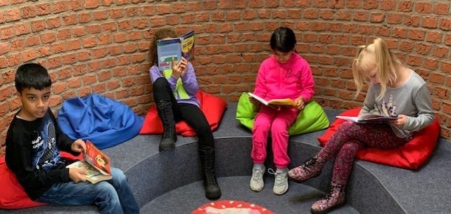 Barn leser i lesekroken